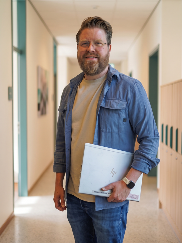 Ramon Visscher loopt door de schoolgang met laptop